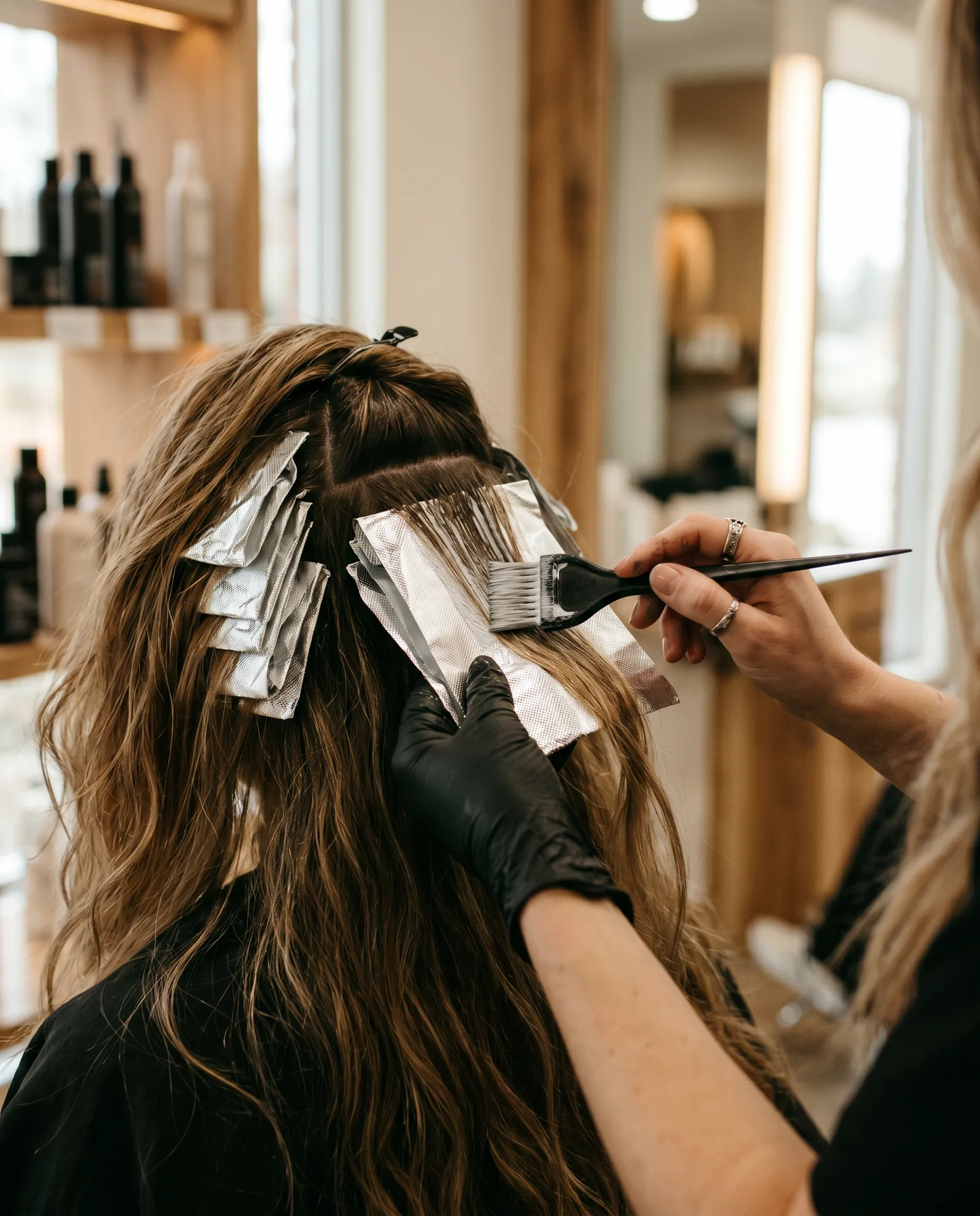 Stylist placing foil highlights in a client’s hair at a Palo Alto salon